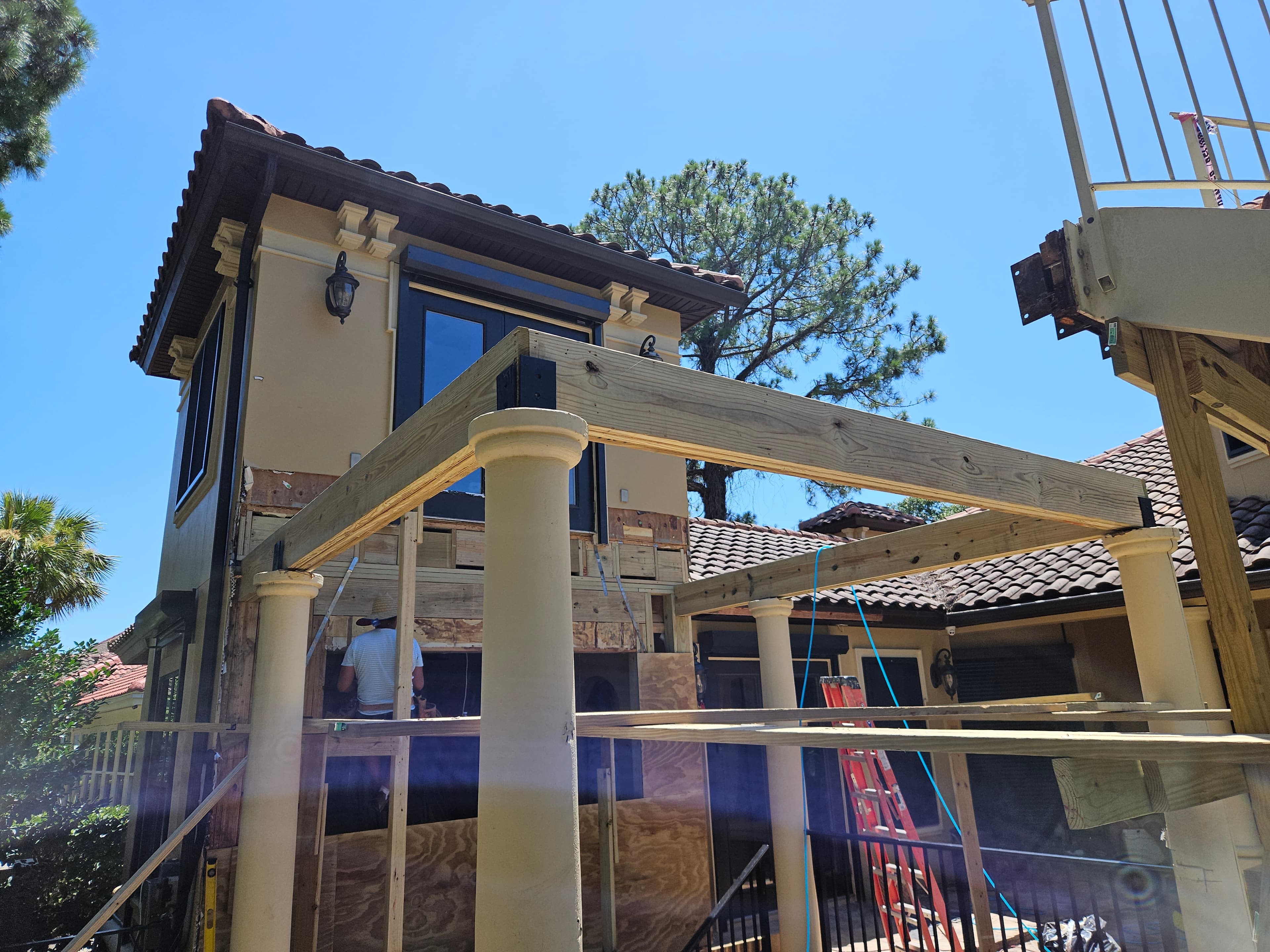 Custom pergola and exterior framing on Mediterranean-style home